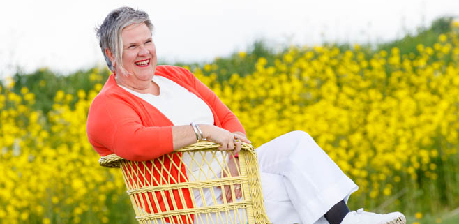photo of Deborah Jorritsma in the meadows of Friesland, the Netherlands. Big smile and yellow flowers all around